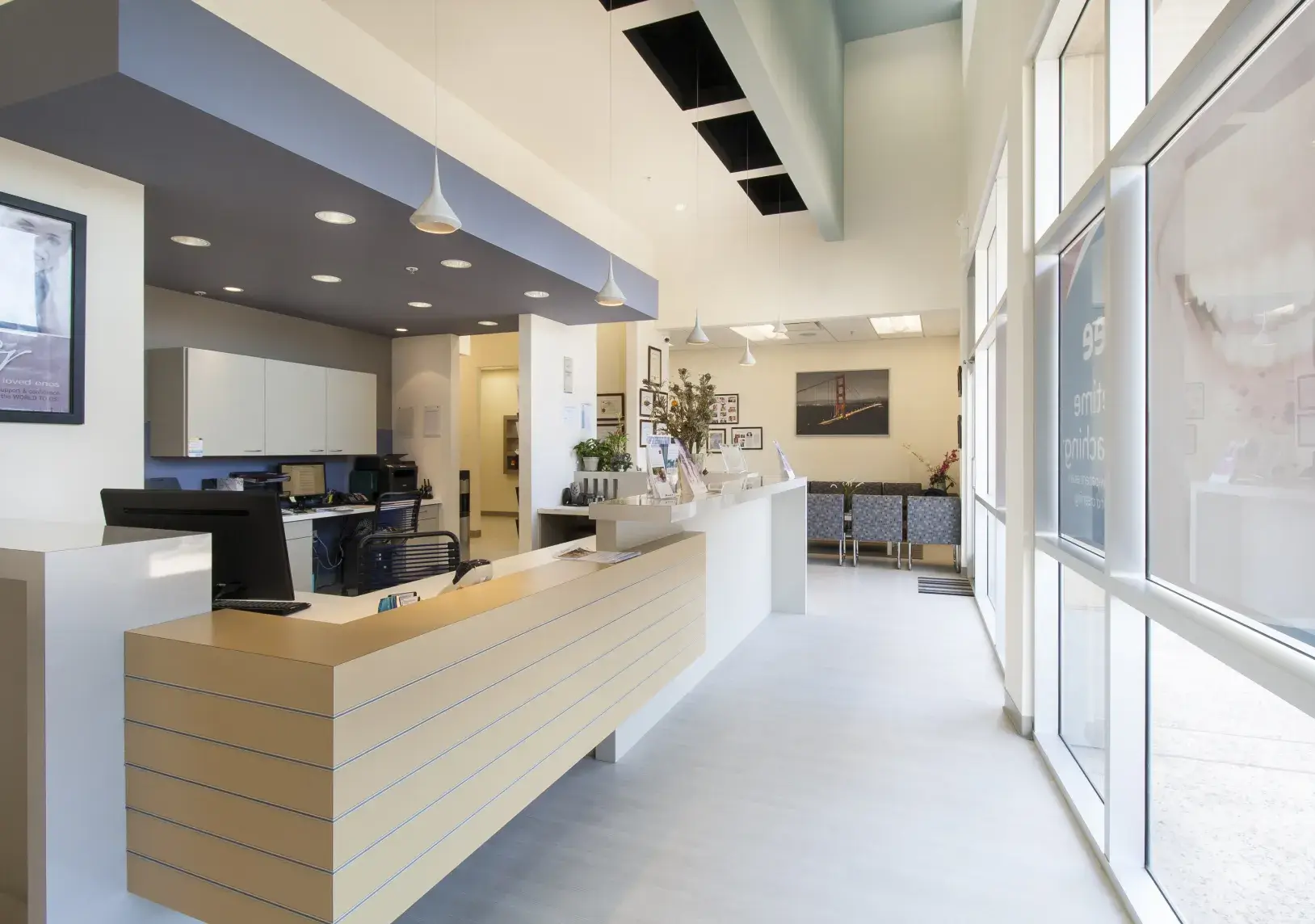 A reception area with a long counter and large windows.